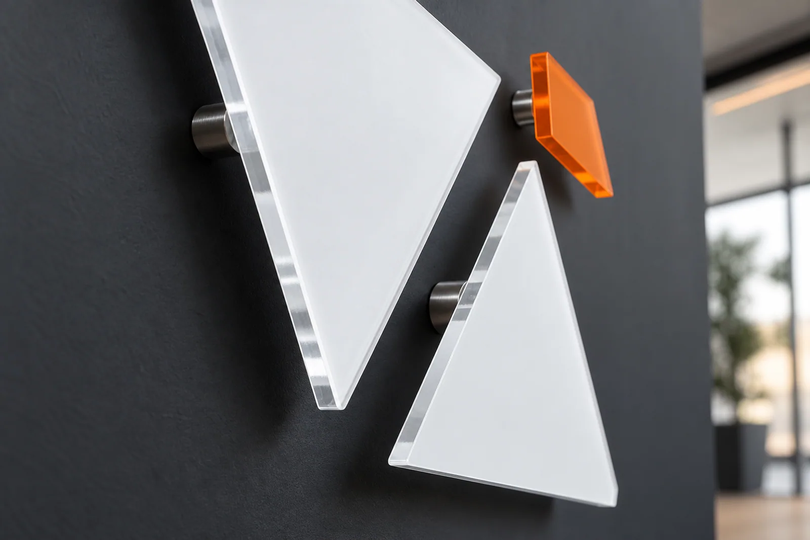 Konzeptvisualisierung: Detail präzise gefertigter Acrylformen mit Edelstahl-Abstandshaltern vor einer matten Wand.