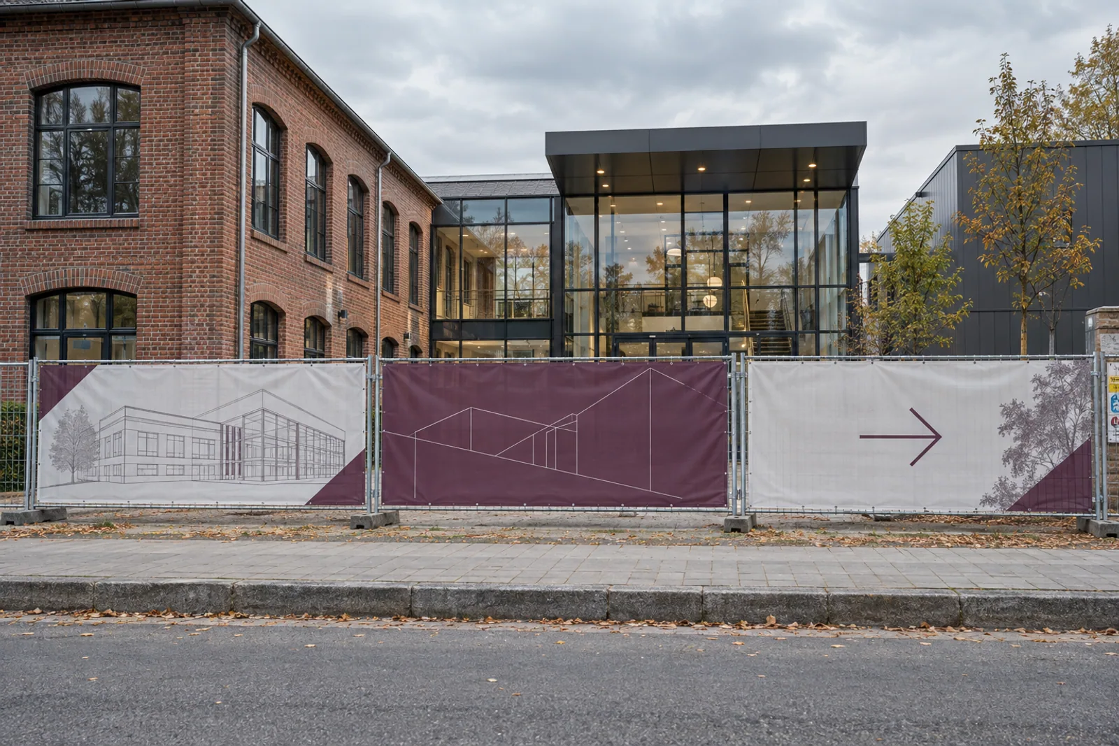 Drei abgestimmte Bauzaunbanner mit Architekturmotiven vor einem modernisierten Backsteingebäude.