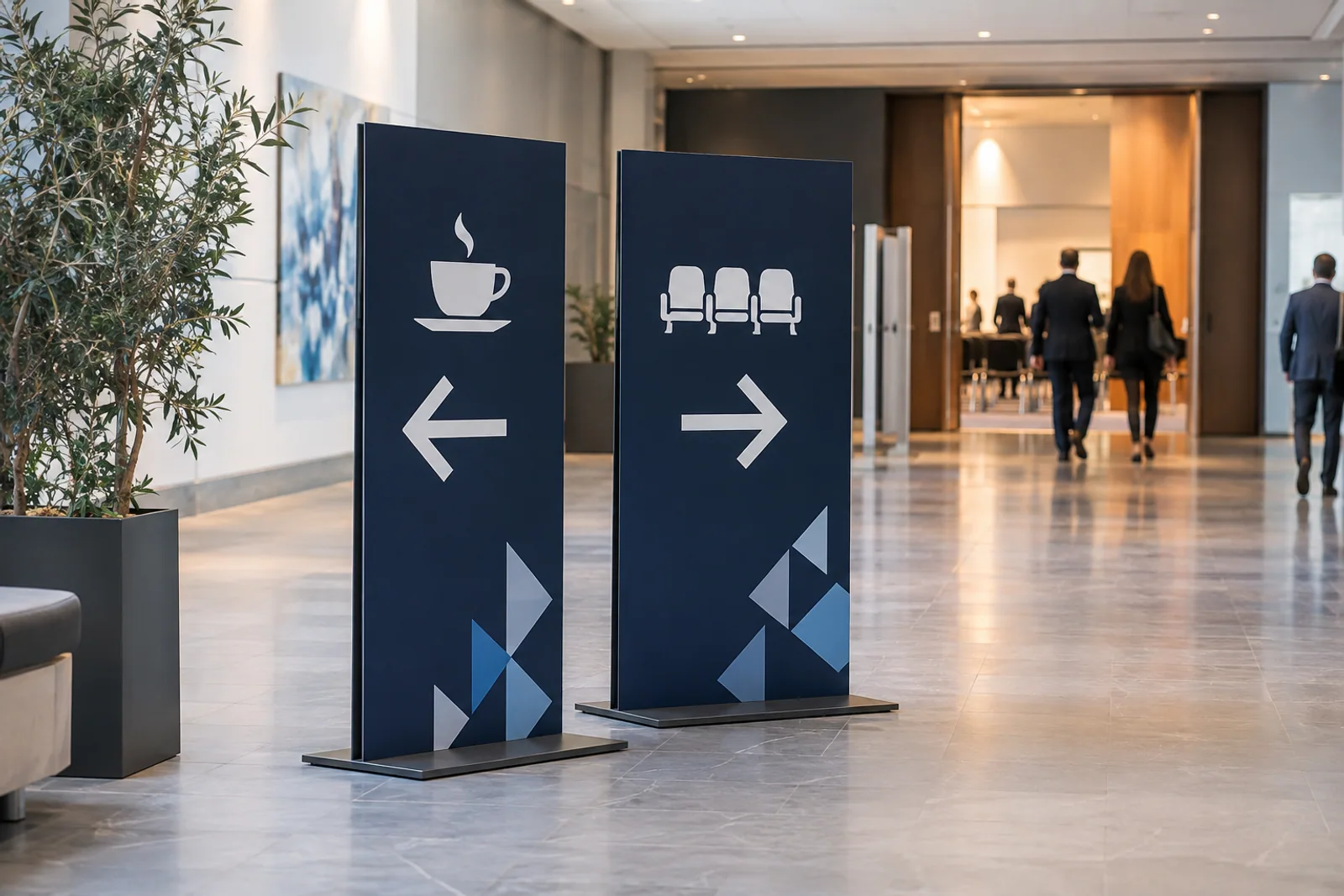 Zwei dunkelblaue Wegweiser mit Kaffee- und Saalpiktogrammen in einem Kongressfoyer.